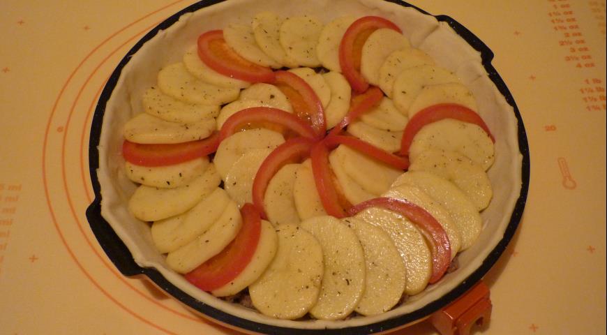 Выложить поверх фарша картофель и помидоры