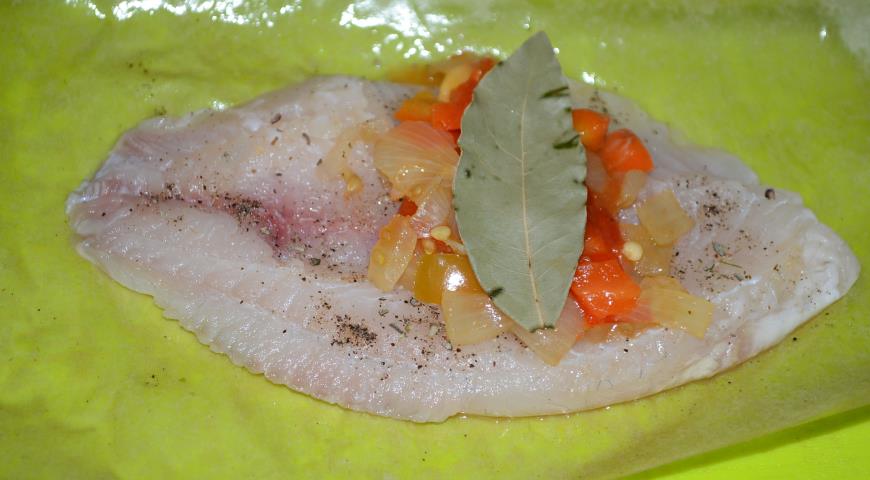 Посыпать рыбу солью и приправой, выложить на нее овощи и лавровый лист