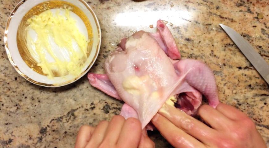Распределить масляную смесь под кожей тушки цыпленка