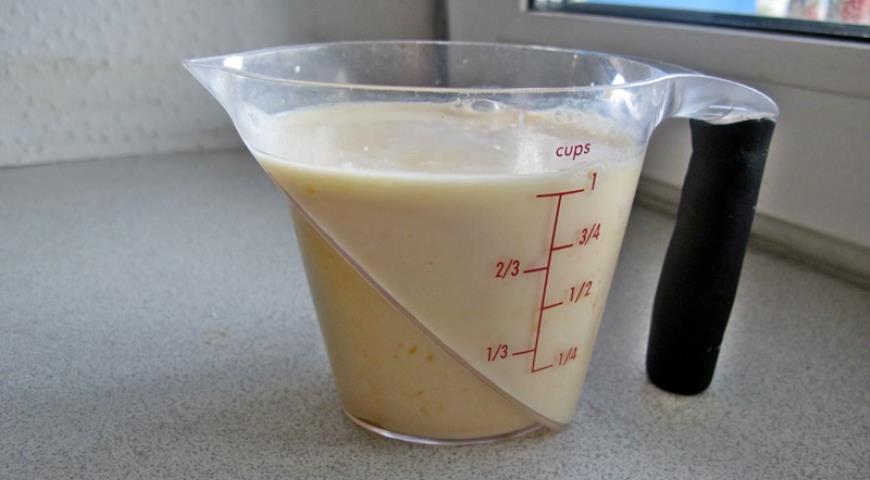 Выжать апельсиновый сок, добавить молоко для приготовления оладий