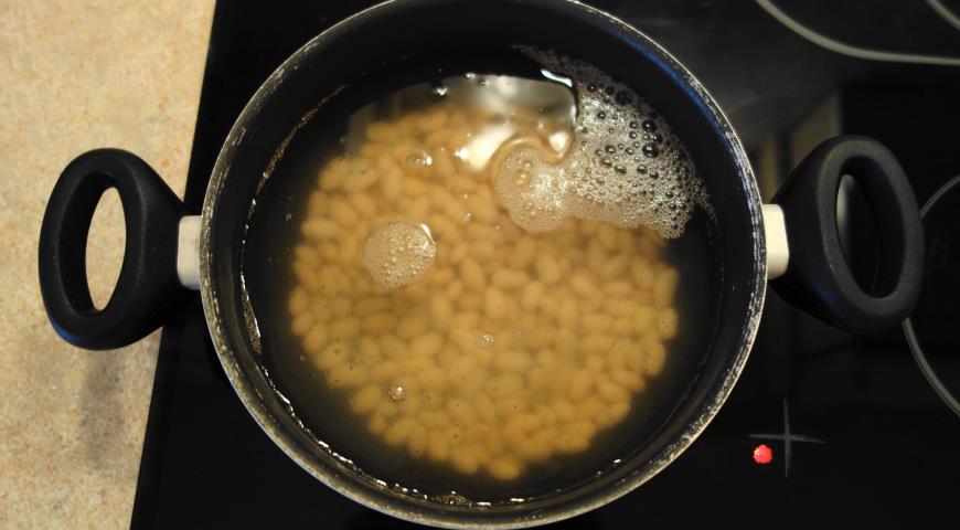 Залить консервированную фасоль с рассолом водой и варить для приготовления щей