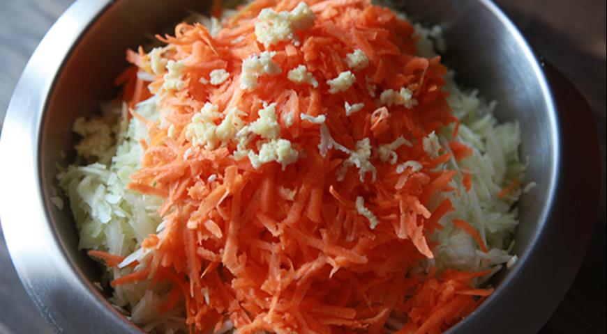 Измельчить морковь и чеснок, перемешать с капустой