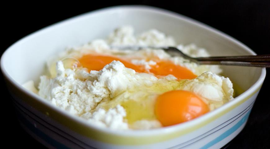 Для приготовления сырников творог смешиваем с яйцами