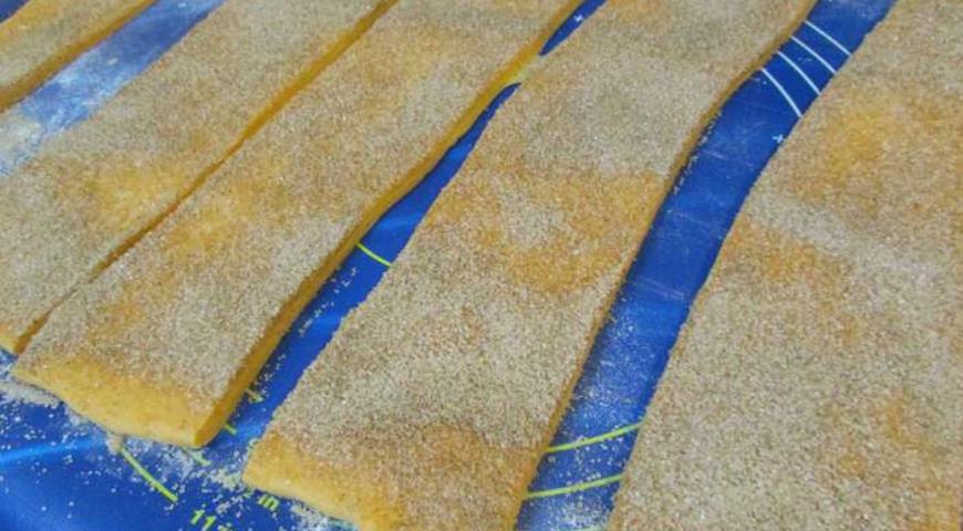 Нарезаем тесто для хлеба полосками и посыпаем сахаром с корицей