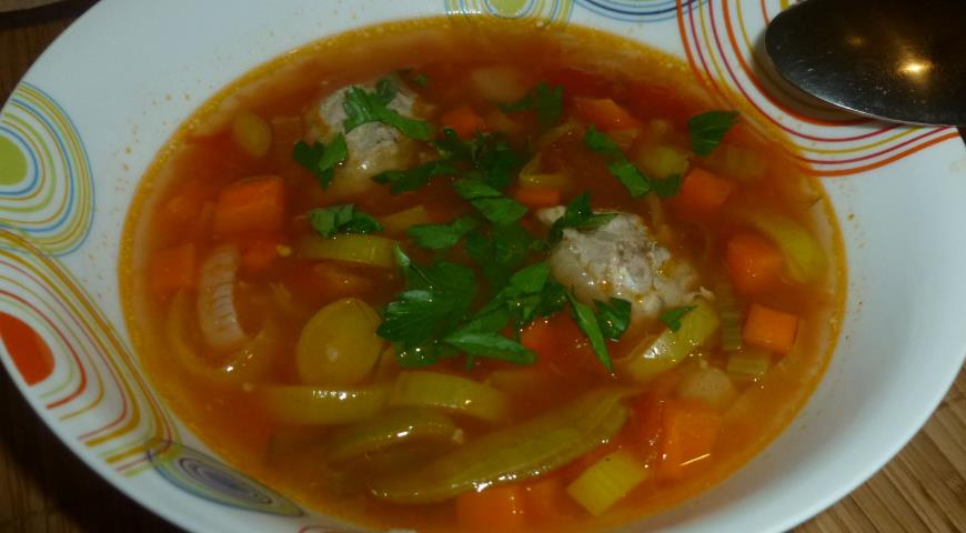 Томатный суп с фрикадельками и пореем перед подачей посыпаем зеленью