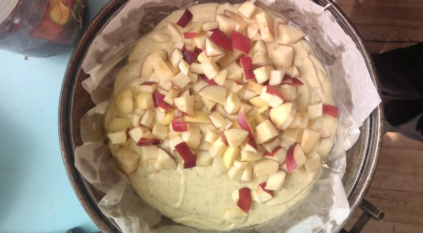 В форму для выпечки выкладываем тесто и яблоки