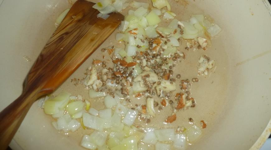 Обжарить лук, добавить к нему смесь чеснока, миндаля и кориандра
