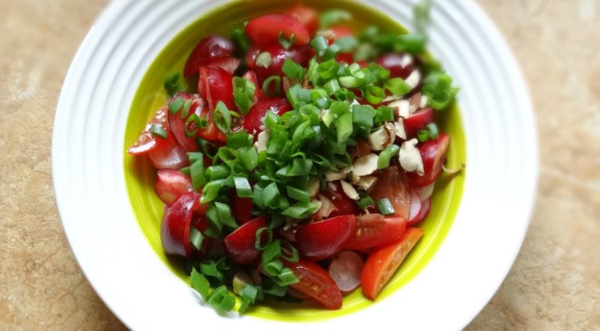 Добавить в салат нарезанные зелень и миндаль
