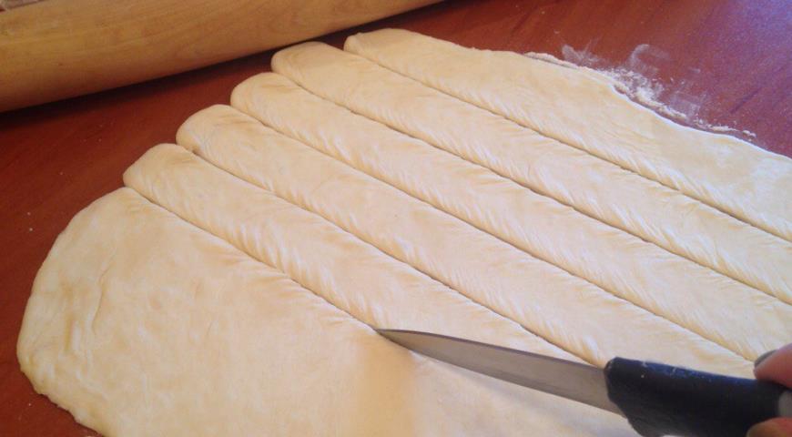 Раскатываем тесто для сосисок с сыром и разрезаем полосами