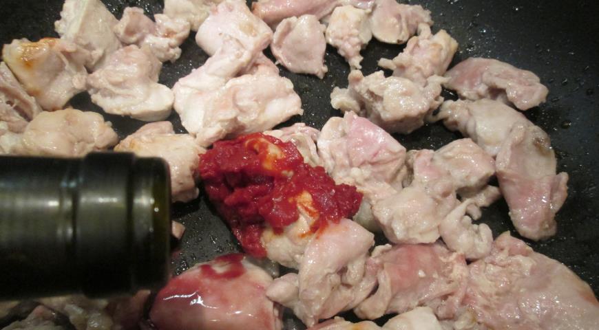 В обжаренные кусочки кролика добавляем томатную пасту и вино