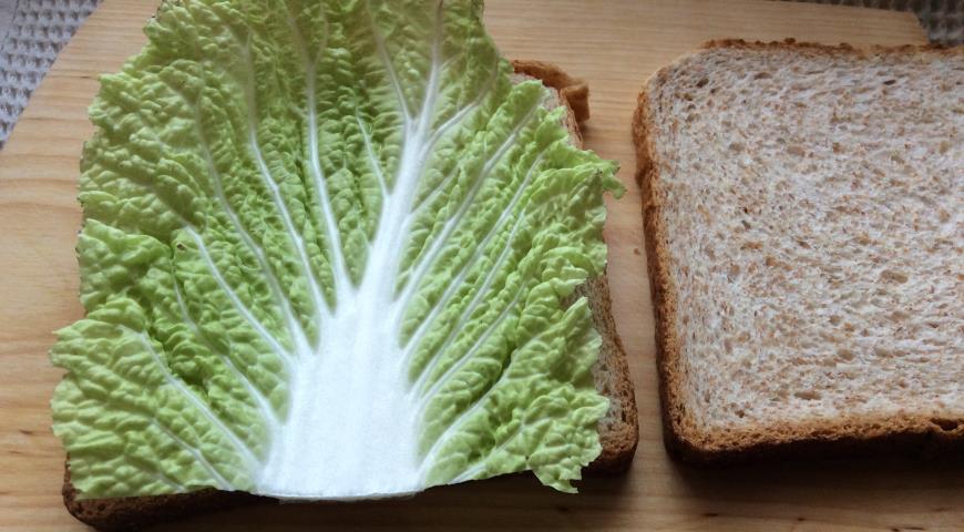 На кусок хлеба для сэндвичей кладем лист пекинской капусты
