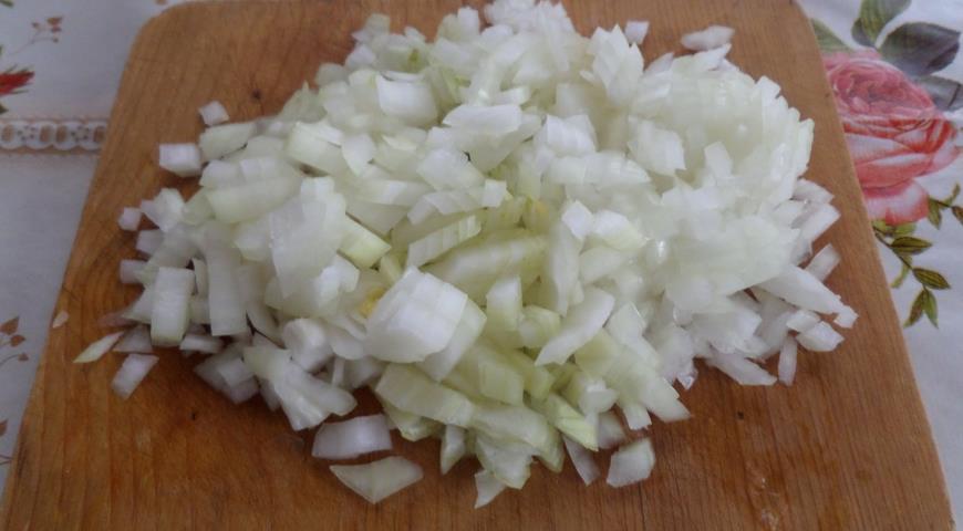 Нарезать лук для приготовления риса с кроликом и овощами