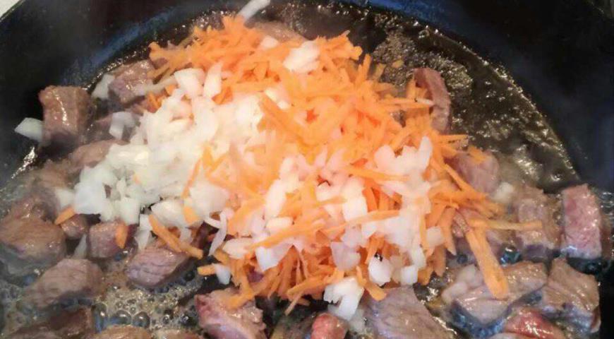 Добавить к мясу нарезанные лук и морковь, тушить 15 минут