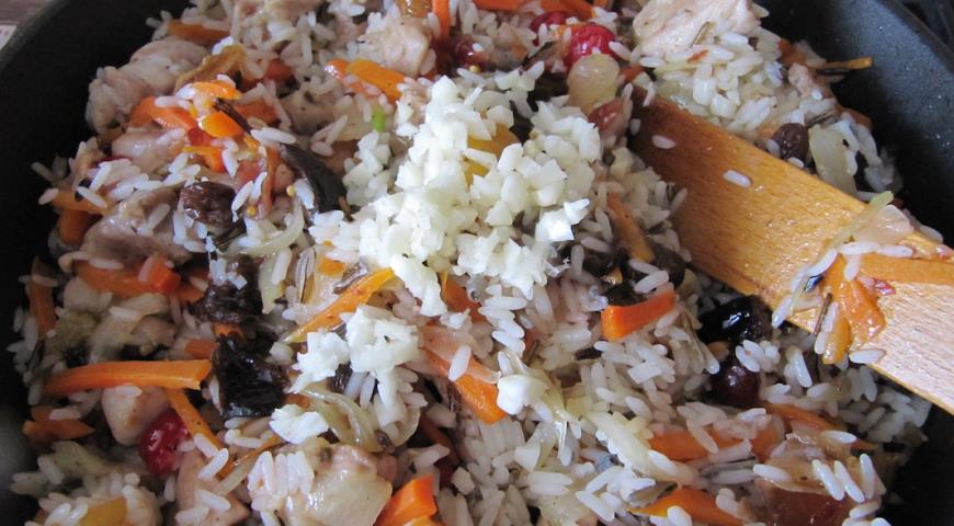 Добавить к обжаренным ингредиентам рис, специи и чеснок