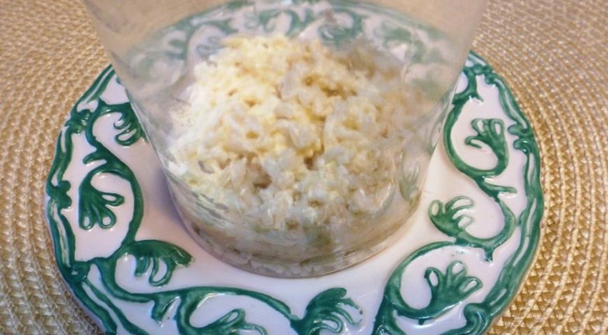 Выложить слой риса, затем лук и укроп, смазав слои майонезом