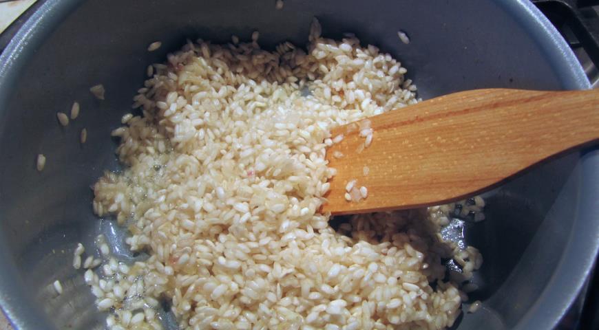 Добавить к луку рис и обжаривать до прозрачности