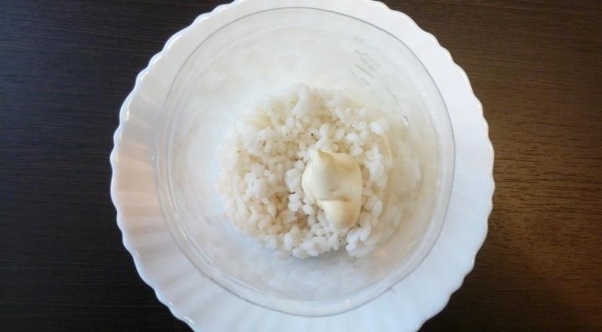 Подготовить ингредиенты, первым слоем выложить вареный рис, смазать его майонезом