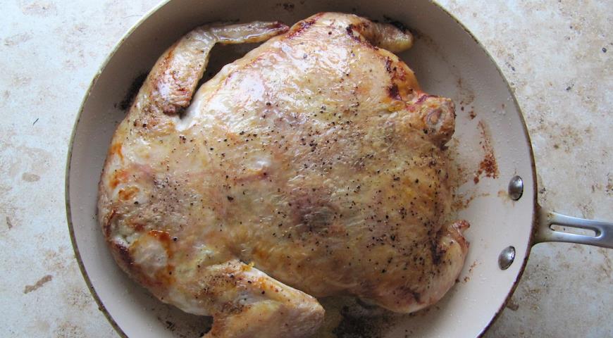 Обжариваем курицу с двух сторон до золотистой корочки, накрыть тарелкой, поставить гнет