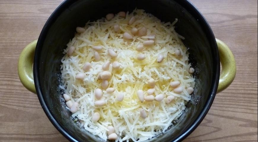 Выложить шпинат, сухари и сыр слоями в форму, сбырзнуть маслом, посыпать орешками, запечь
