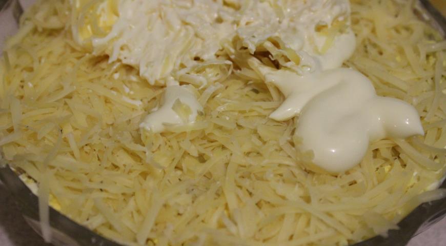 Добавляем тертый сыр и промазываем верхний слой салата майонезом