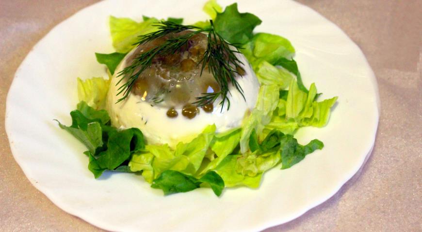 Перевернуть заливное на тарелки, украсить листьями салата и веточками укропа