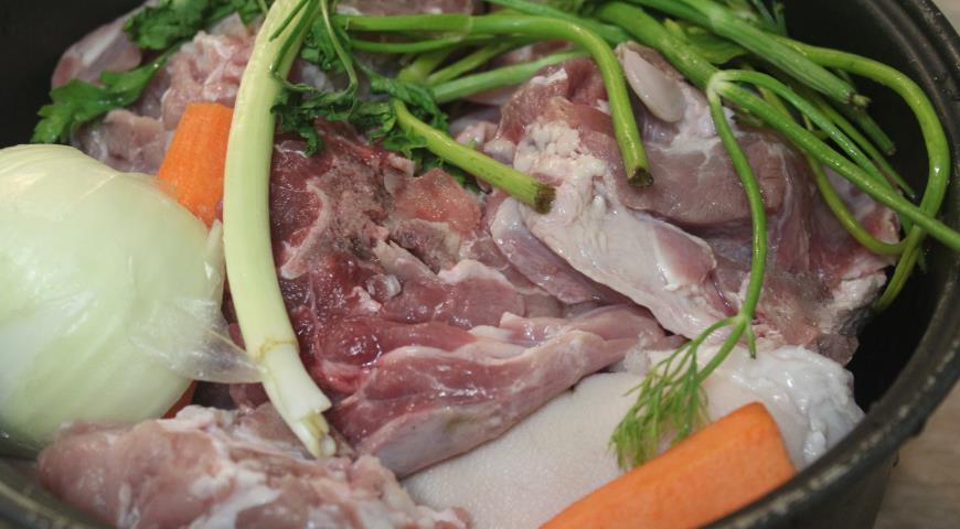 Мясо складываем в мультиварку, добавляем лук, морковь и зелень