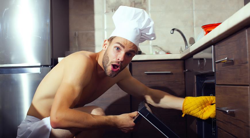 Мужсина голый готовит на кухне
