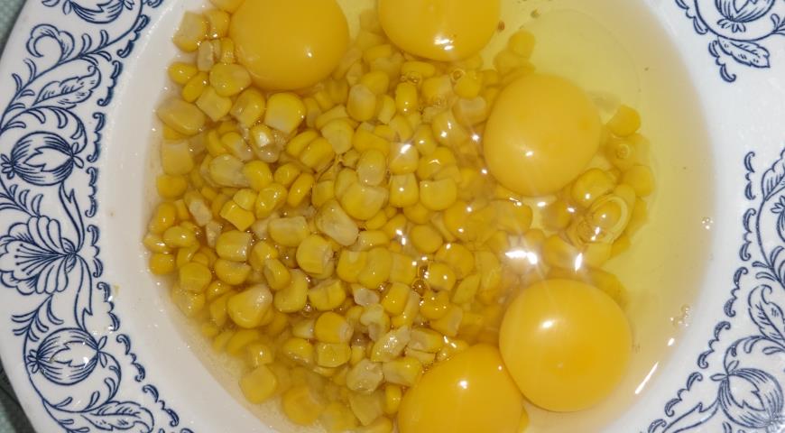 Для приготовления омлета разбиваем яйца, добавляем консервированную кукурузу