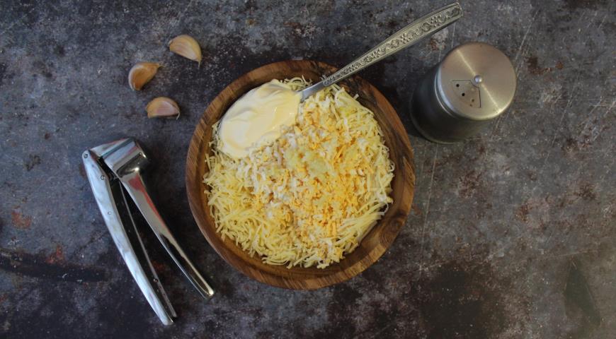 Смешиваем в миске натертый сыр, мелко натертые сваренные яйца, чеснок и майонез