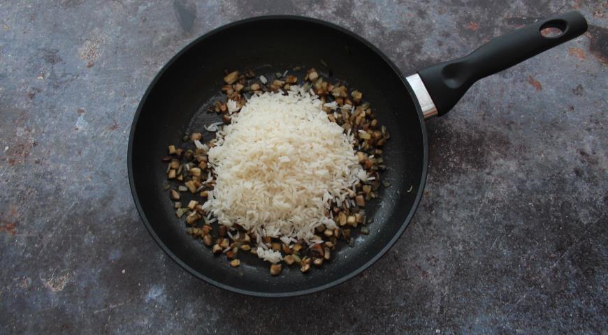 Добавляем слегка остывший рис к овощам, солим и перчим
