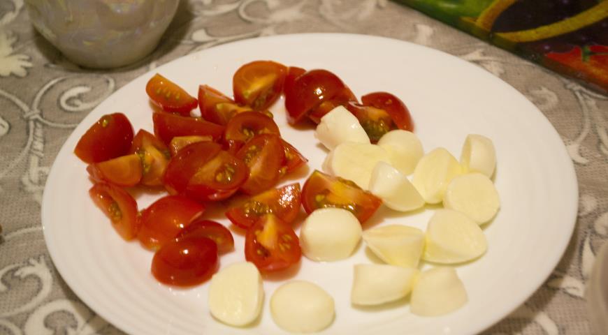 Нарезаем помидоры черри на 4 части, кусочки моцареллы на 2 части