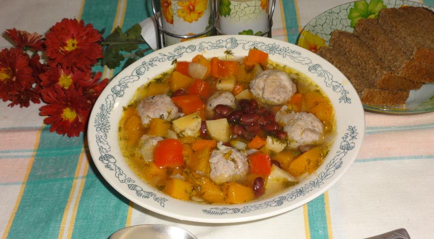 Горячий овощной суп с фрикадельками разлить по тарелкам