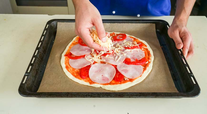 Пицца на кефире, сверху разложите ветчину и помидоры, посыпьте сыром