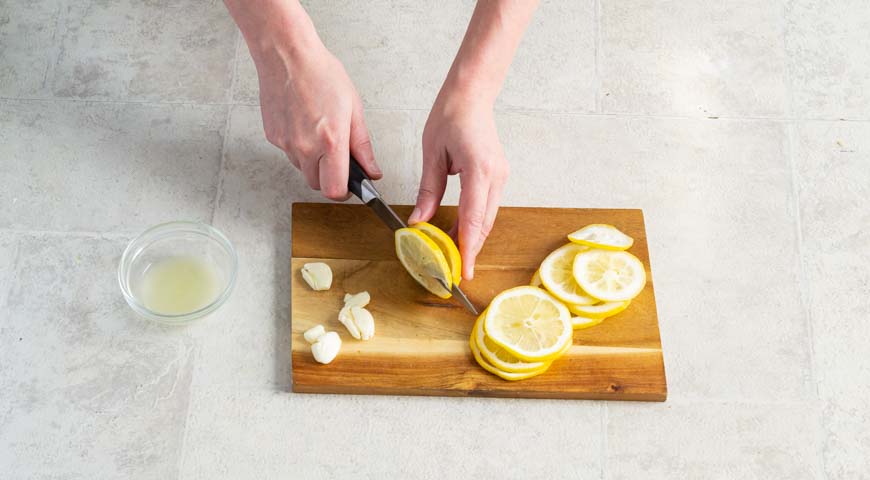 Дорадо, нарежьте лимон тонкими кружками, выжмите сок