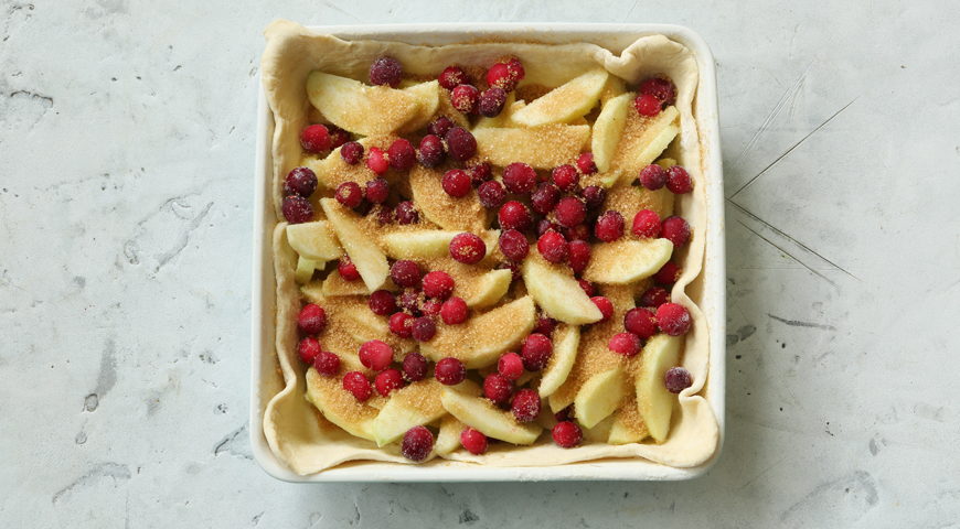 Пирог с яблоками и клюквой, выложите яблоки и клюкву на тесто
